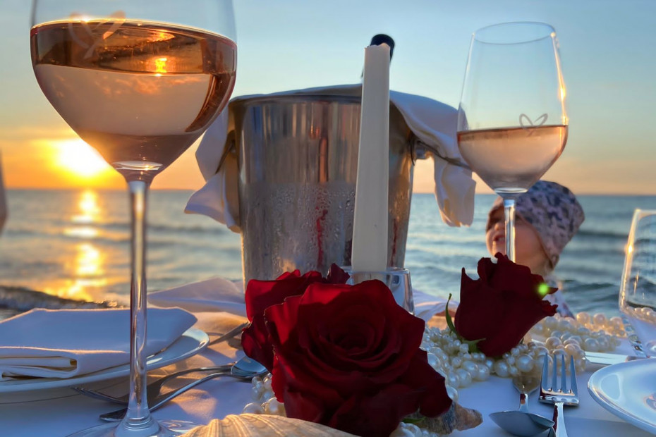 gedeckter Tisch mit Wein bei Sonnenuntergang am Strand des Strandhotel Fischlands