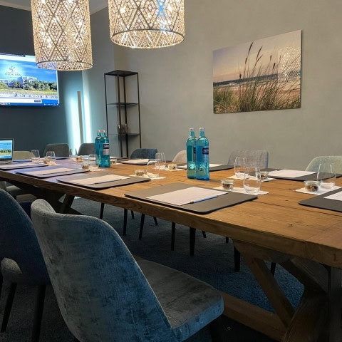 Boardingroom mit großen Tisch, Stühlen und Fernseher im Strandhotel Fischland