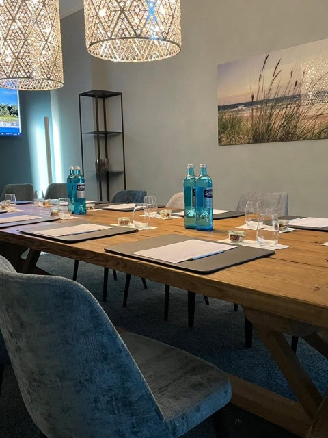 Boardingroom mit großen Tisch, Stühlen und Fernseher im Strandhotel Fischland