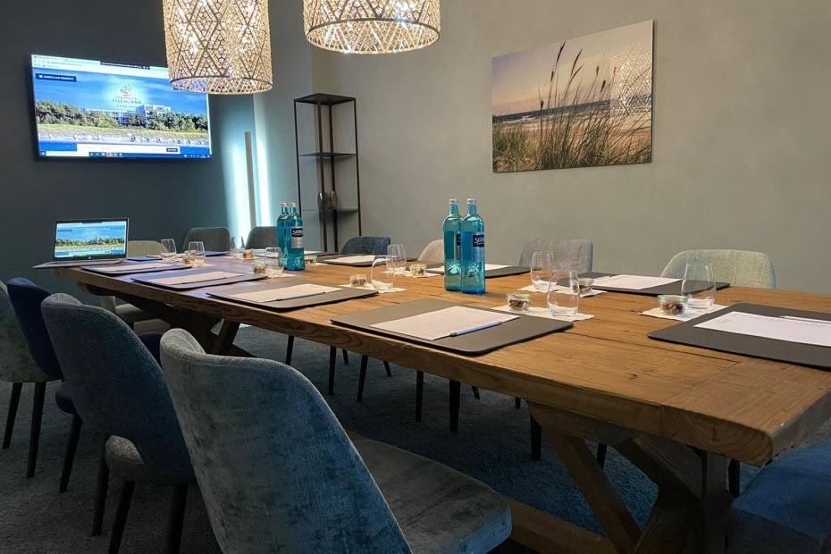 Boardingroom mit großen Tisch, Stühlen und Fernseher im Strandhotel Fischland