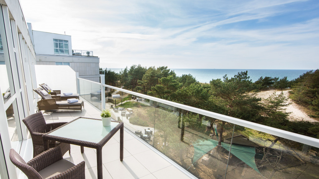 Balkon im Strandhotel Fischland mit Liegen, Tisch und Stühlen sowie Blick auf die Ostsee