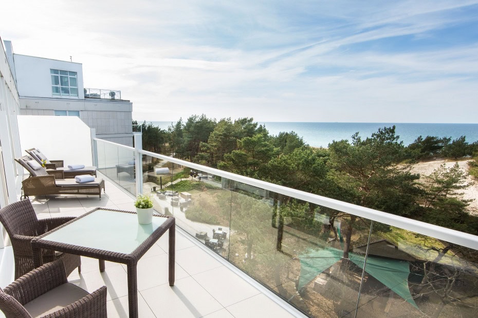 Balkon im Strandhotel Fischland mit Liegen, Tisch und Stühlen sowie Blick auf die Ostsee