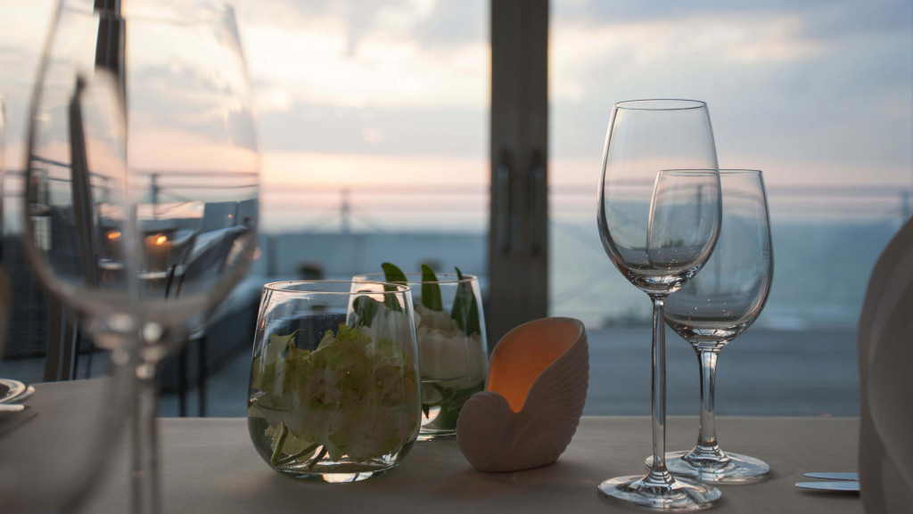 Tisch mit Weingläsern, Muscheldekoration und Blumen im Strandhotel Fischland
