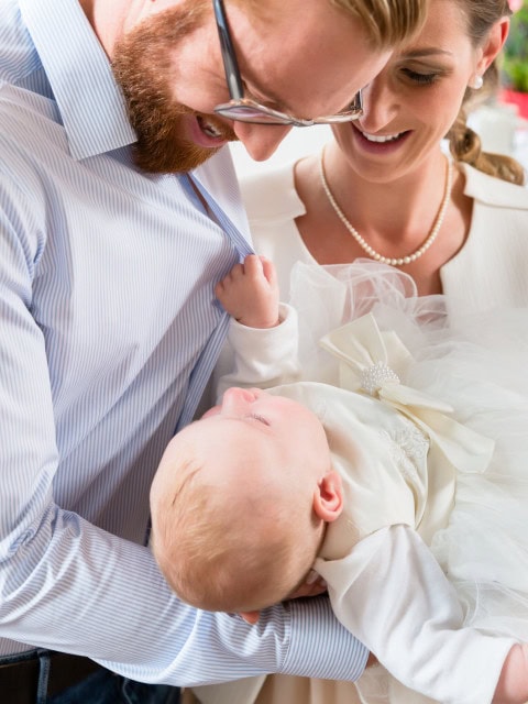 Eltern und Baby bei Taufe in der Kirche