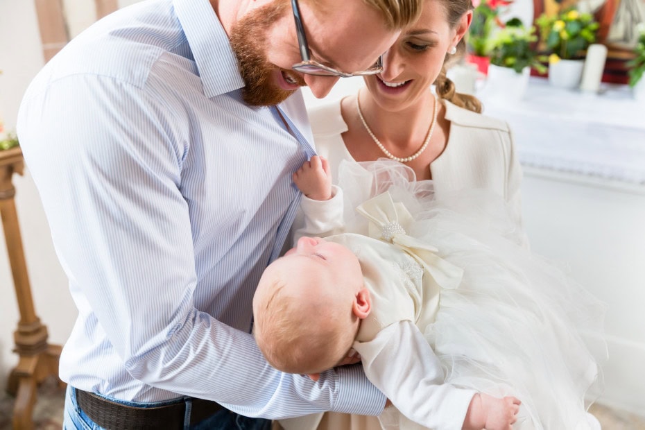 Eltern und Baby bei Taufe in der Kirche