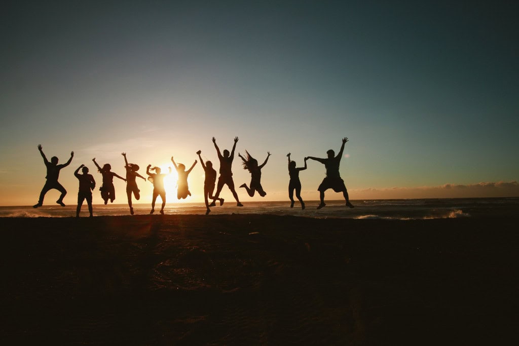 springende Menschen am Strand der Ostsee