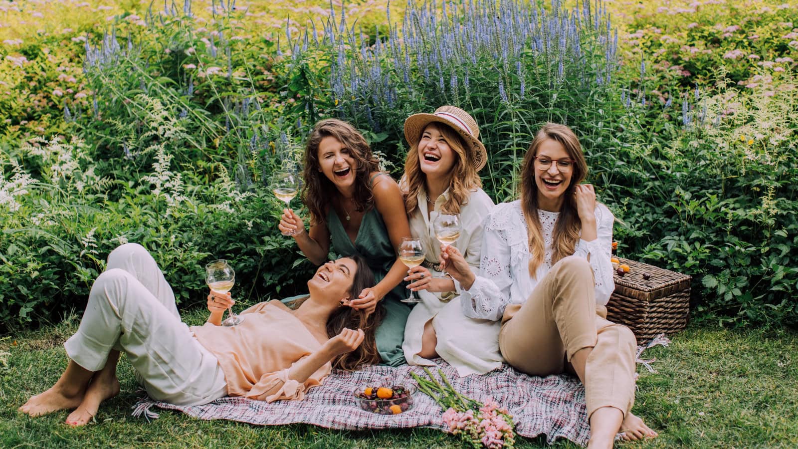 Frauen beim Picknick mit Wein und Früchten