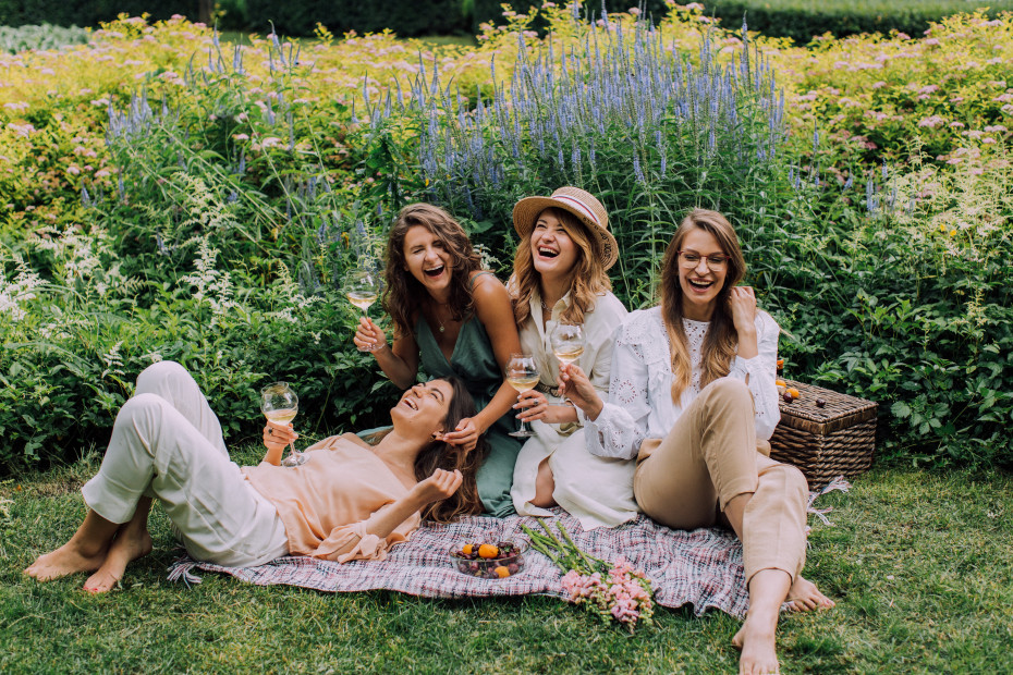 Frauen beim Picknick mit Wein und Früchten