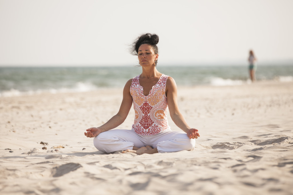 Yogalehrerin des Strandhotel Fischlands bei der Meditation am Strand