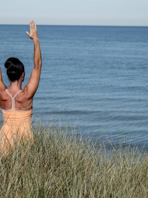 Yogalehrerin des Strandhotel Fischlands macht Yoga in den Dünen