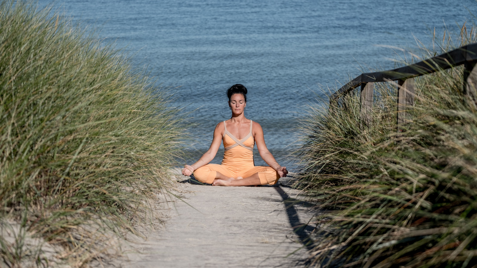 Yogalehrerin macht Yoga in den Dünen des Strandhotel Fischlands