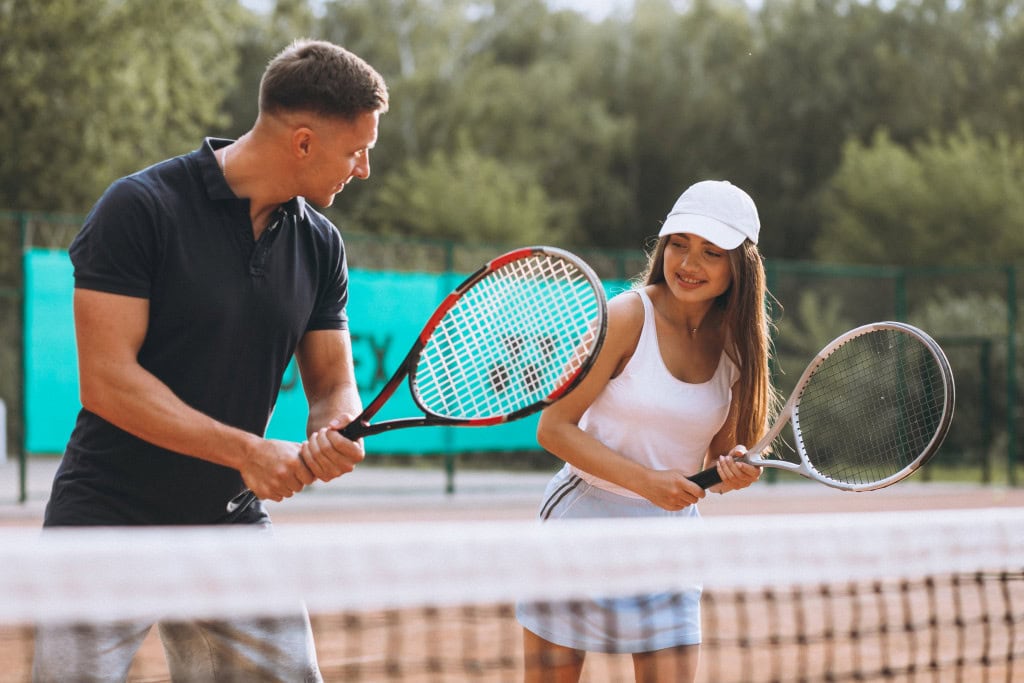 Junges Paar spielt Tennis im Strandhotel Fischland