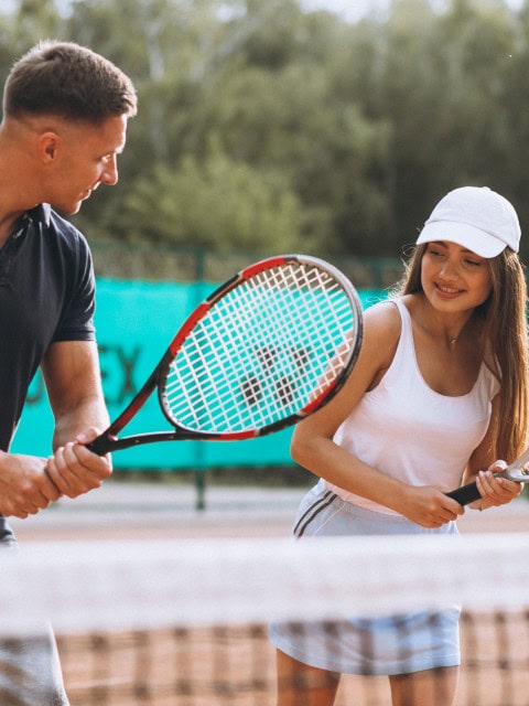 Junges Paar spielt Tennis im Strandhotel Fischland