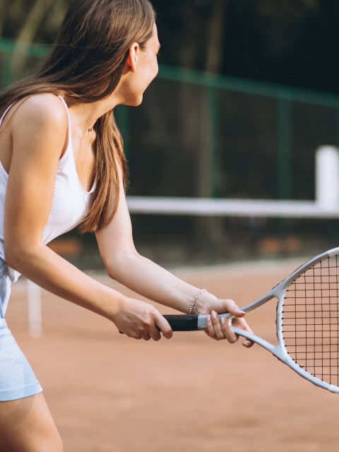 Junge Frau beim Tennisspielen im Strandhotel Fischland