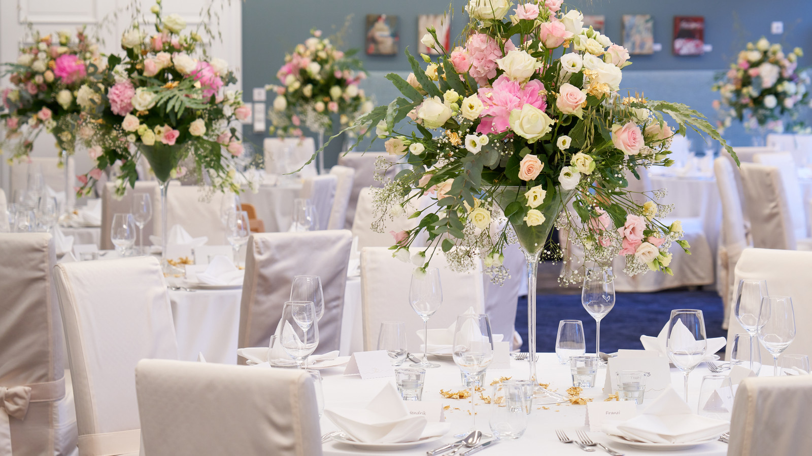gedeckte runde Tische mit Blumendekoration für Hochzeit im Strandhotel Fischland
