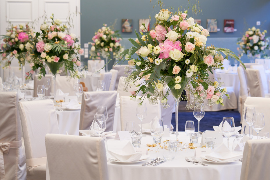 gedeckte runde Tische mit Blumendekoration für Hochzeit im Strandhotel Fischland
