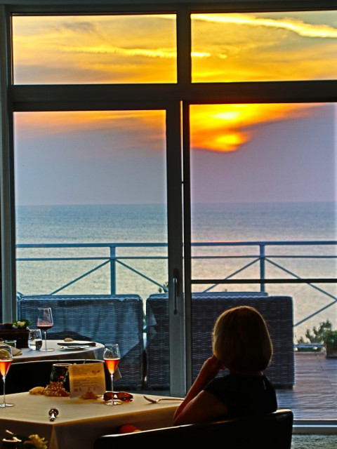 Blick auf die Ostsee bei Sonnenuntergang in der Ostseelounge im Strandhotel Fischland