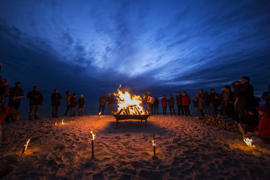 Fackeln und Lagerfeuer am Strand des Strandhotel Fischlands mit Akkordeonspieler