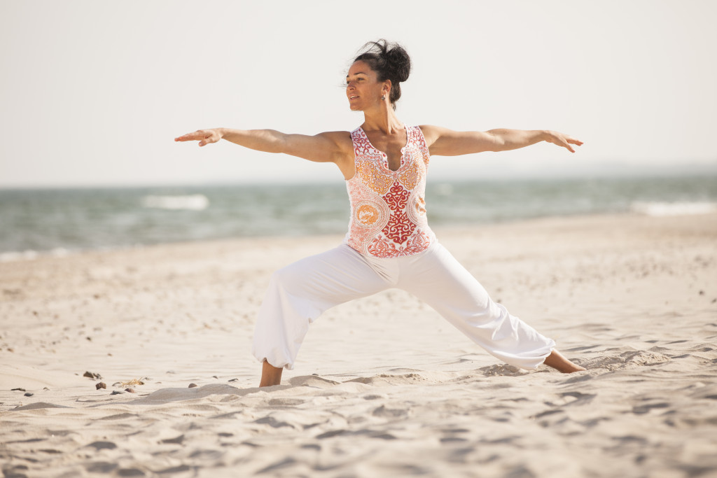 Yogalehrerin des Strandhotel Fischlands macht Yoga am Strand