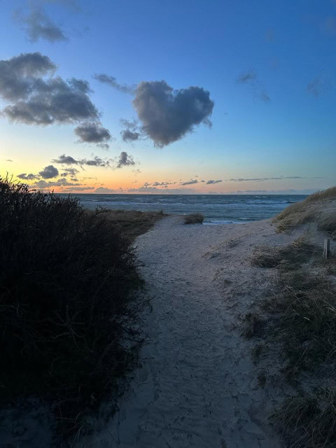 Weg zum Strand bei Sonnenuntergang mit Herzwolke am Himmel