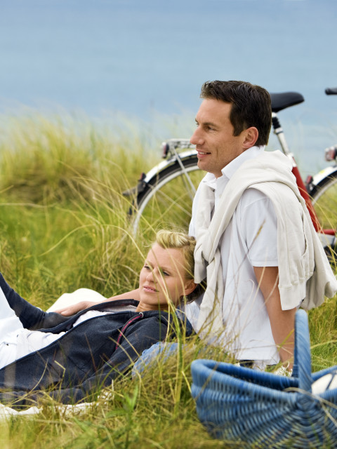 Paar beim Picknick während Radtour mit Fahrrädernd es Strandhotel Dünenmeers