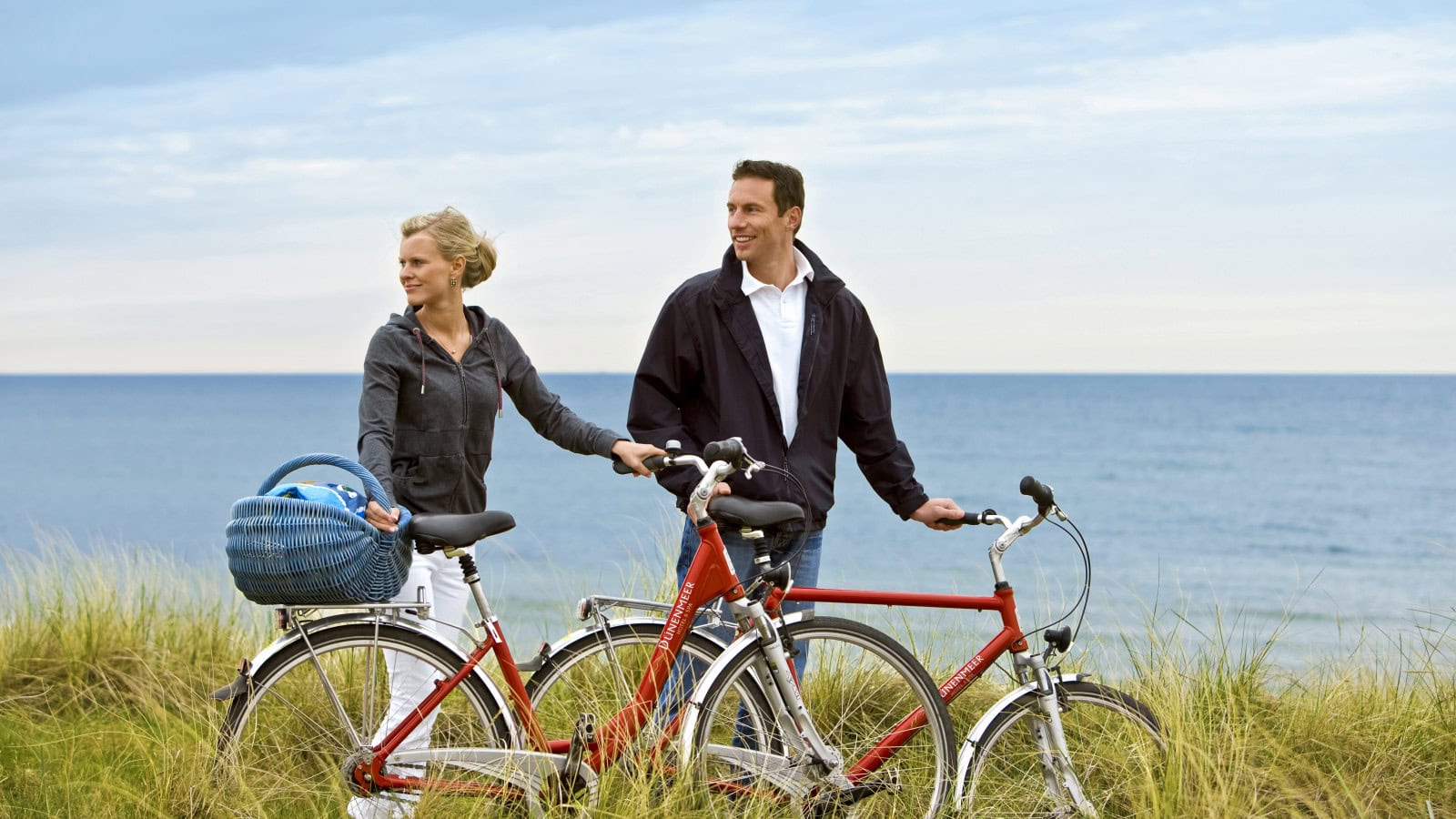 Paar mit Fahrrädern des Strandhotel Dünenmeers in den Dünen der Ostsee