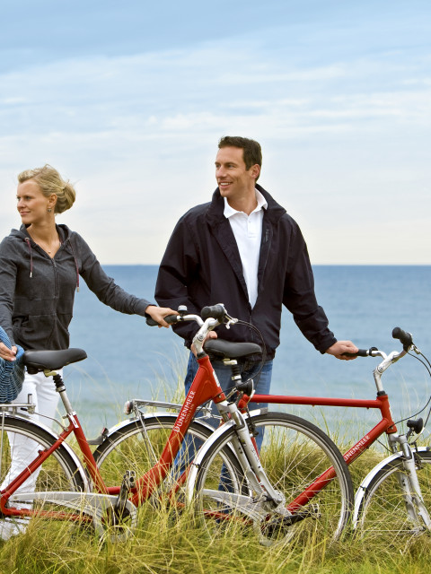 Paar mit Fahrrädern des Strandhotel Dünenmeers in den Dünen der Ostsee
