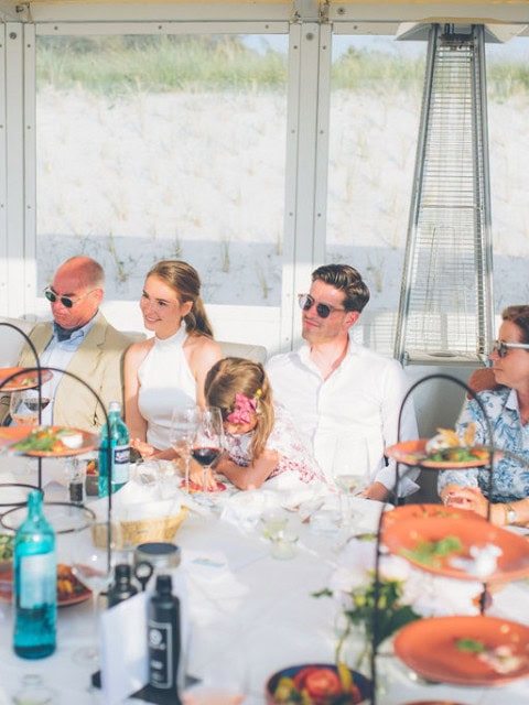 Brautpaar mit Gästen beim Essen in der Strandbude des Strandhotel Fischlands