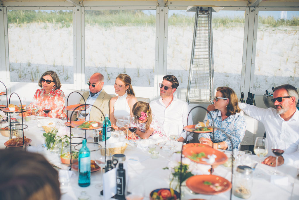 Brautpaar mit Gästen beim Essen in der Strandbude des Strandhotel Fischlands