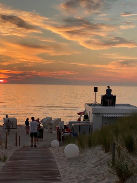 Strand mit Strandkörben und DJ bei Sonnenuntergang im Strandhotel Fischland