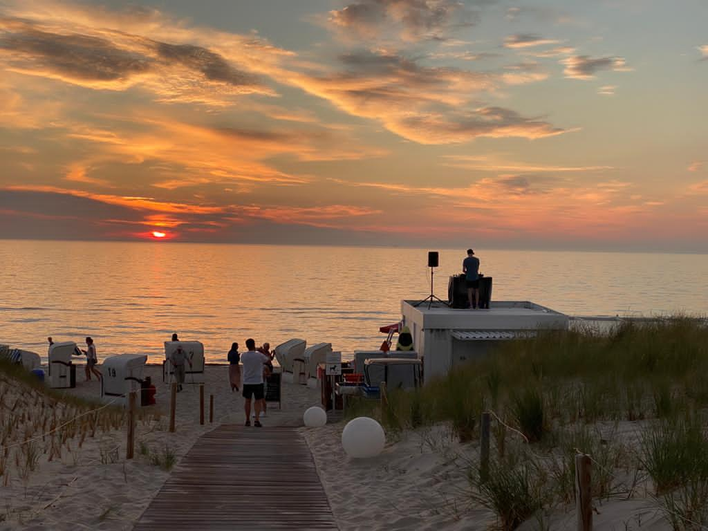 Strand mit Strandkörben und DJ bei Sonnenuntergang im Strandhotel Fischland