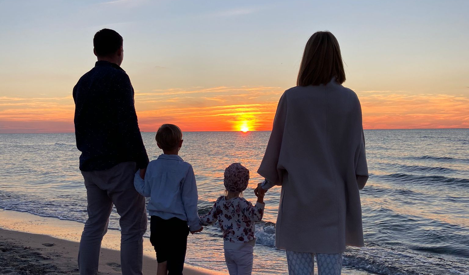Familie mit Kindern beim Sonnenuntergang im Strandhotel Fischland
