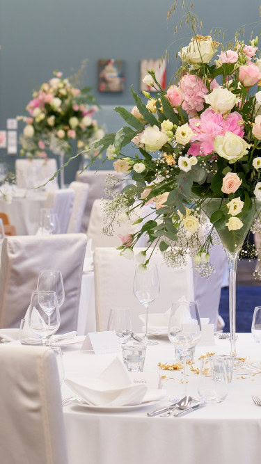eingedeckte Tische für eine Hochzeit mit Blumendekoration im Strandhotel Fischland