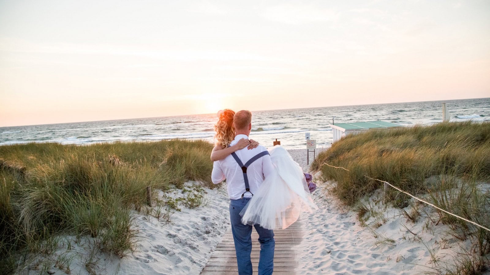 Brautpaar auf dem Weg zum Strand vom Strandhotel Fischland