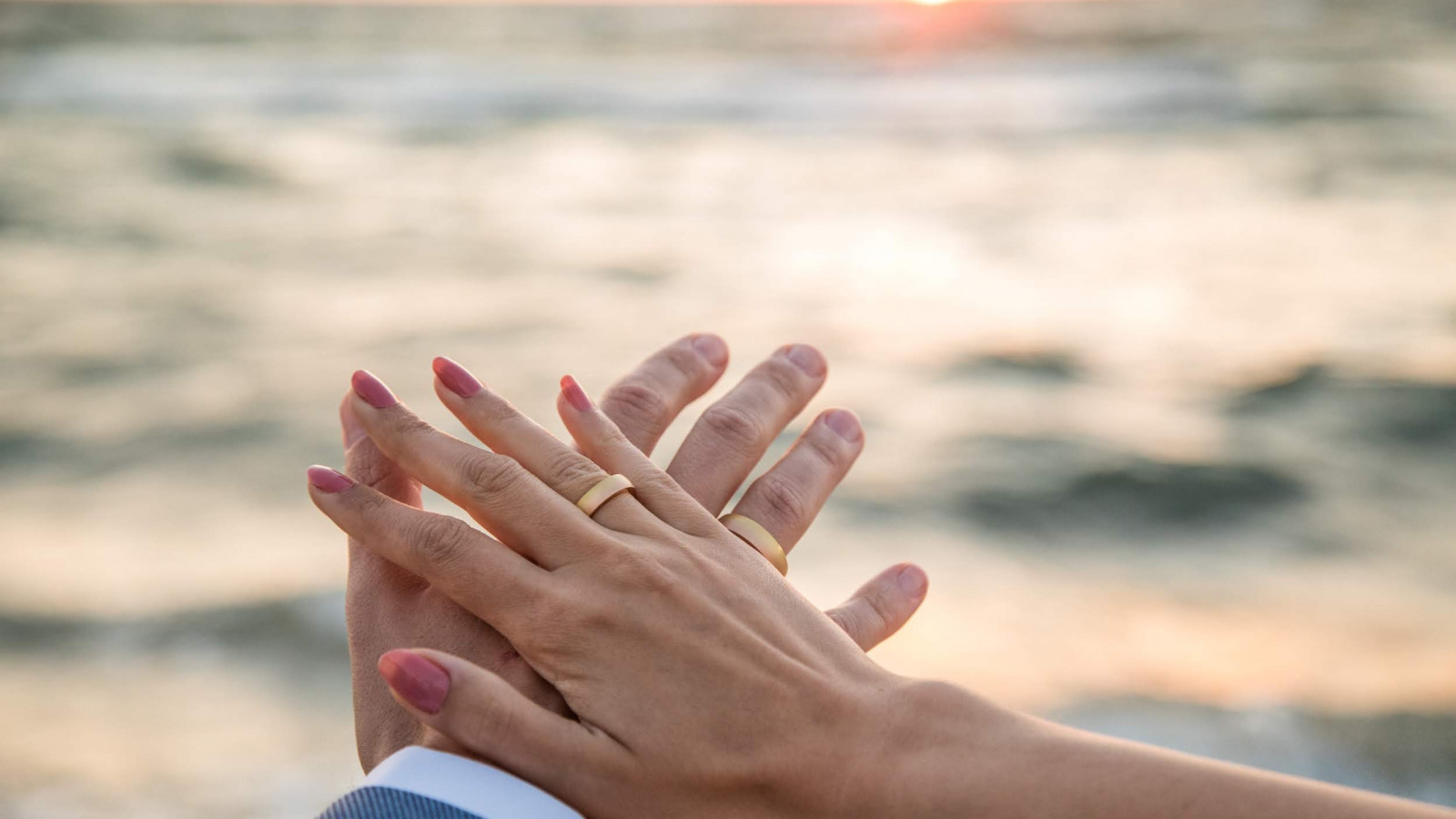 Hände des Brautpaares mit Hochzeitsringen im Strandhotel Fischland