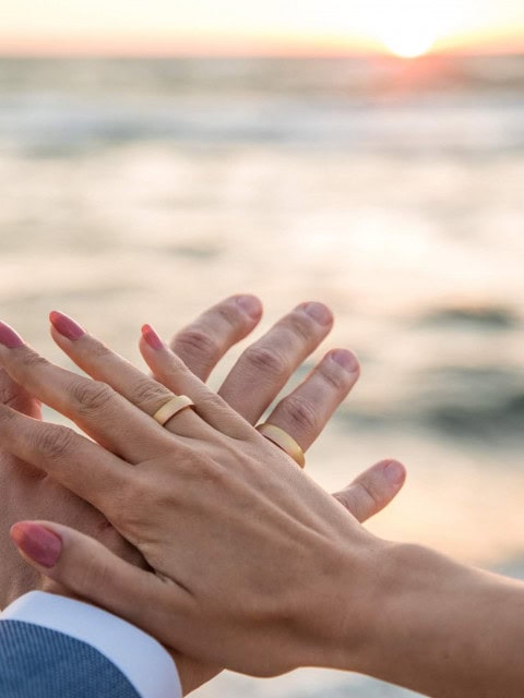 Hände des Brautpaares mit Hochzeitsringen im Strandhotel Fischland