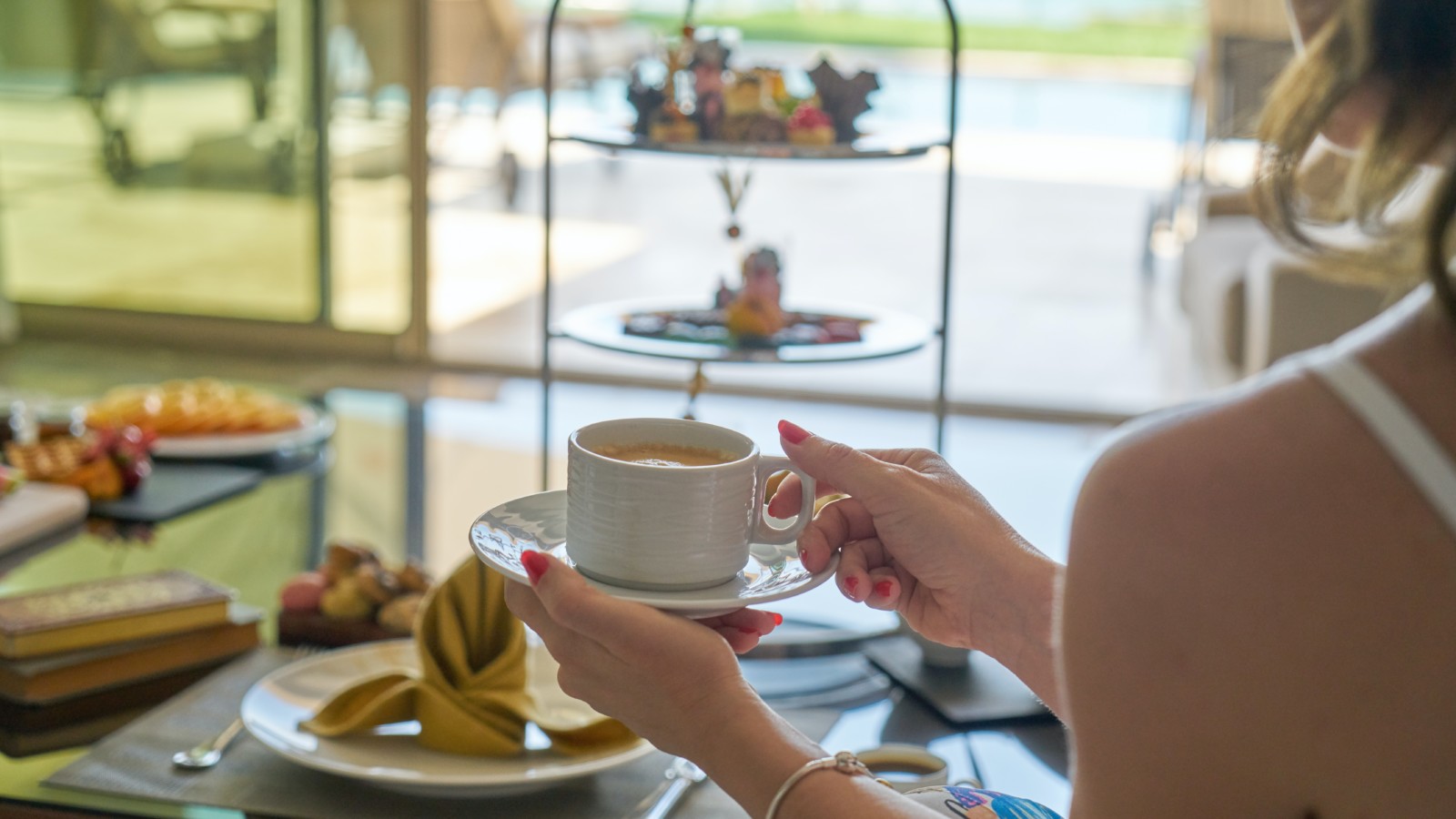 Frau hält einen Kaffee in der Hand am Frühstücksbuffet im Strandhotel Fischland