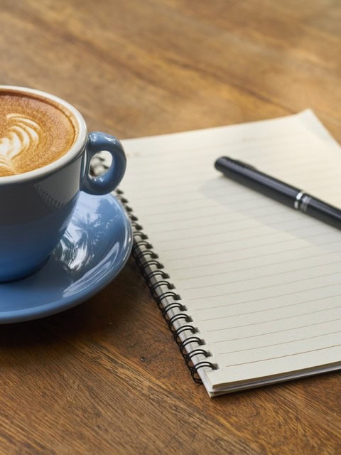 Kaffeegenuss, Kaffeetasse mit einen Block mit Stift zum notieren von Gedanken