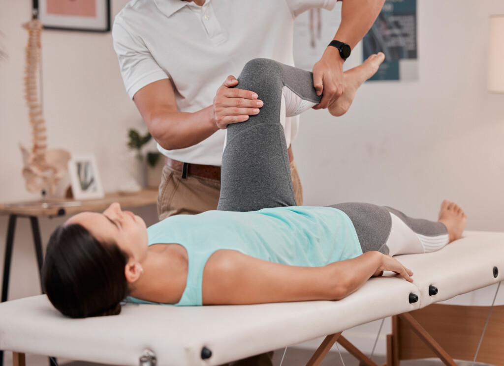 Leg, physiotherapy and healthcare of woman at hospital for rehabilitation, recovery or wellness. Help, physical therapy or female patient with chiropractor for stretching, knee pain or injury healing