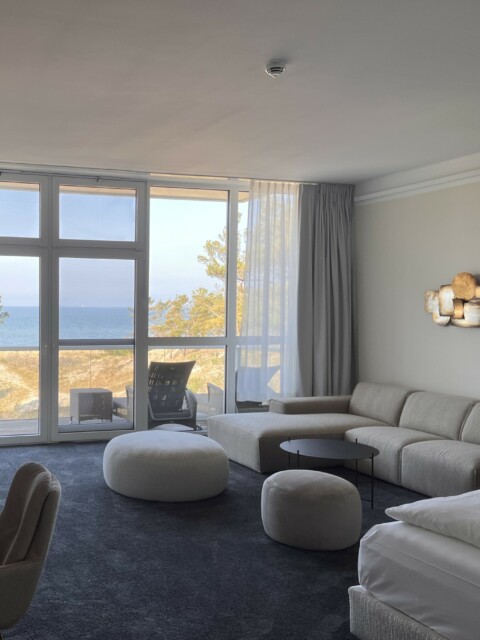 Suite im Strandhotel Fischland, Hauptraum mit Doppelbett, Couch, TV und Blick auf die Ostsee